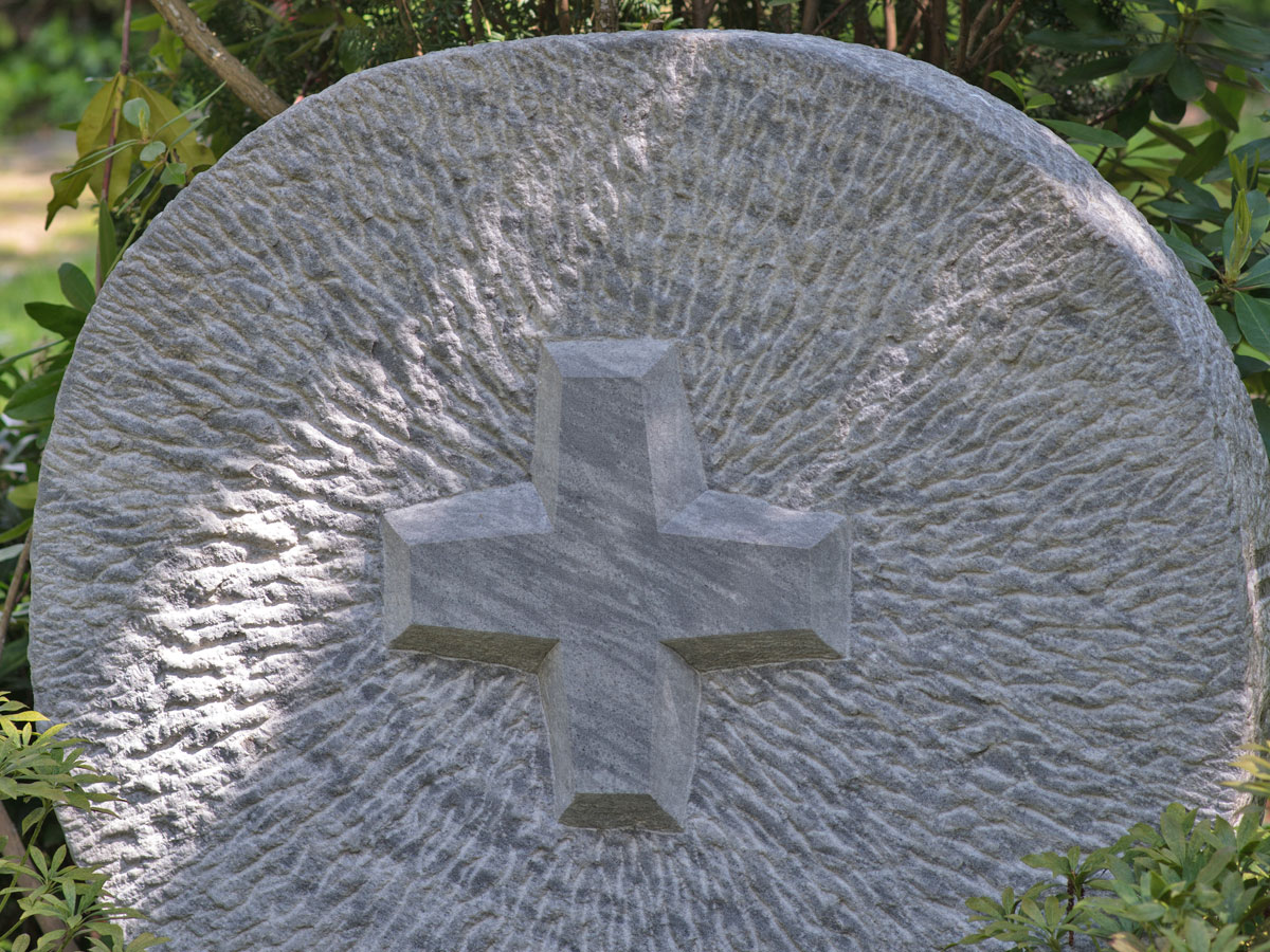 Runder Grabstein mit herausgearbeiteten Kreuz